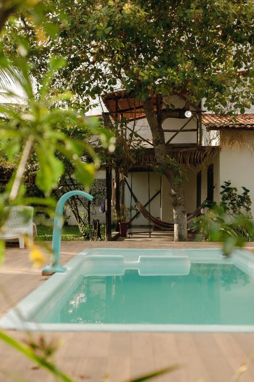 a swimming pool with a water slide in a yard at Pura Vida Hostel e Pousada - Boipeba in Ilha de Boipeba