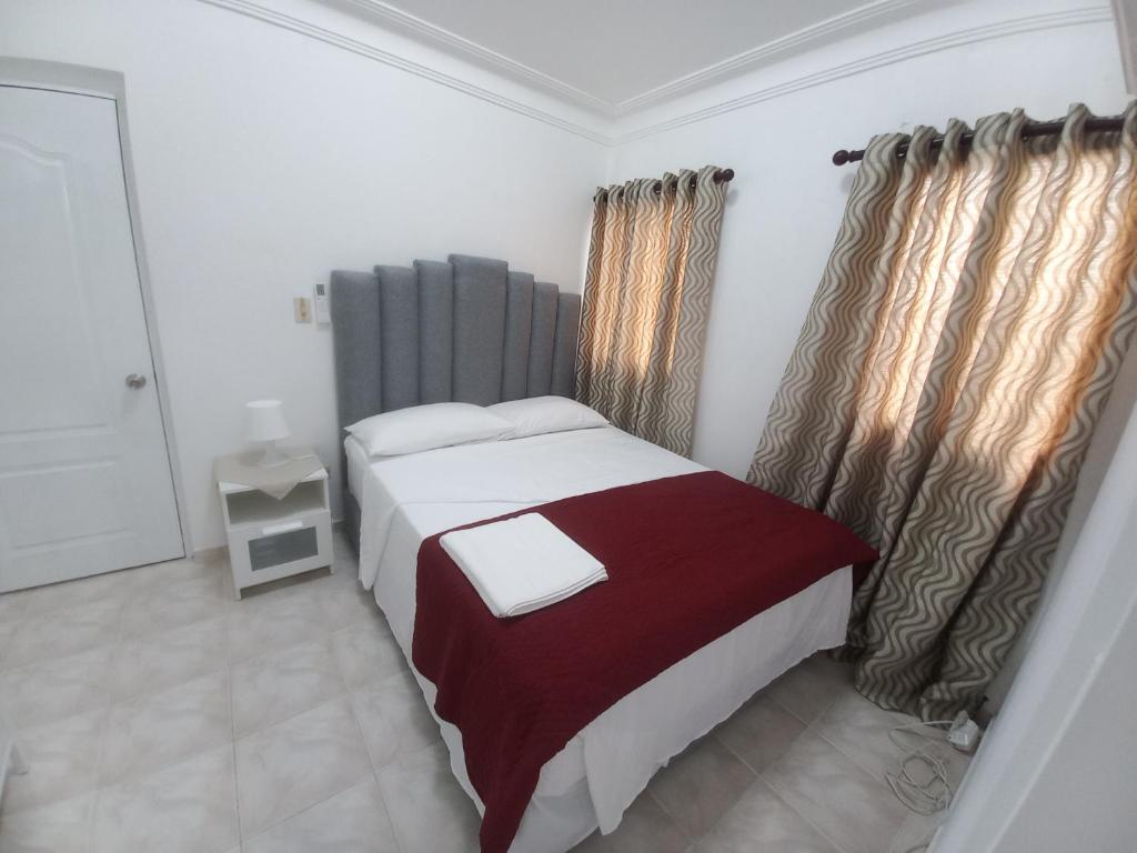 Casa Petter og Maria في سانتياغو دي لوس كاباليروس: غرفة نوم بها سرير كبير وبطانية حمراء