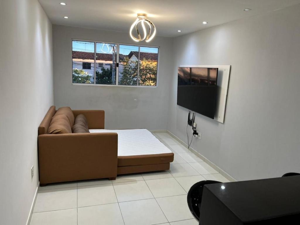 ein Wohnzimmer mit Sofa und Flachbildfernseher in der Unterkunft Cabo de Santo Agostinho Apartmento in Cabo de Santo Agostinho