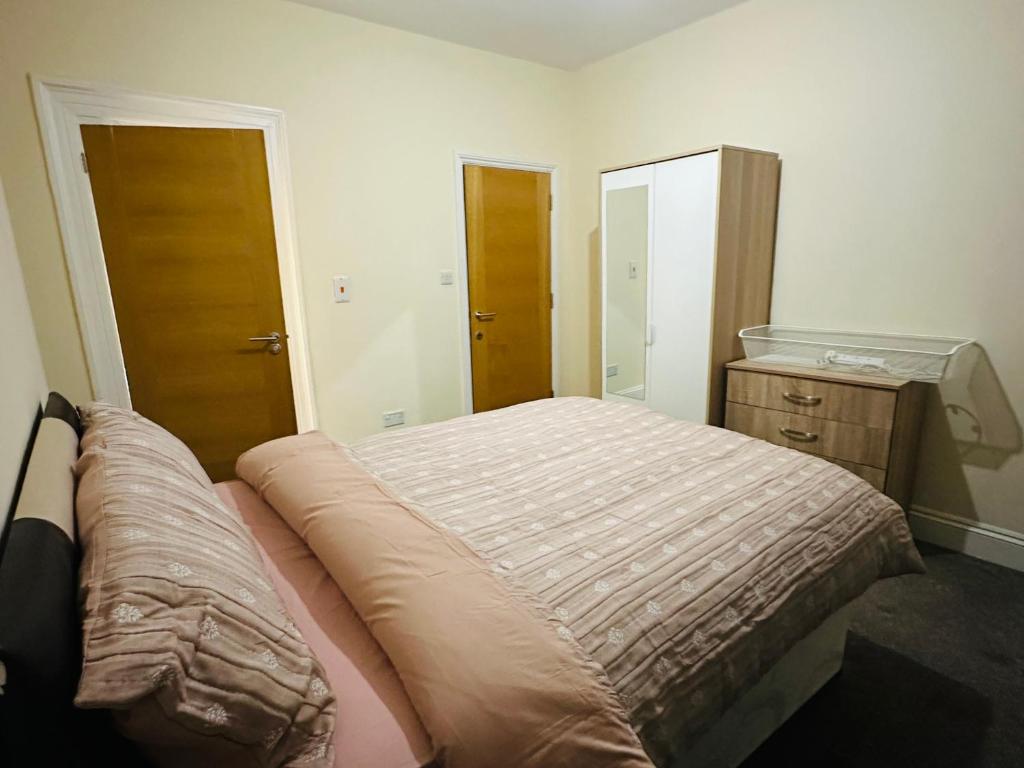 - une chambre avec un grand lit et une armoire en bois dans l'établissement The Albert, Montpellier, à Bristol