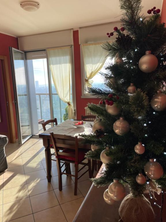 a christmas tree in a living room with a table at Skyline 15 Milano - Panoramic Apartment and Free Parking - Metro M1 in Milan