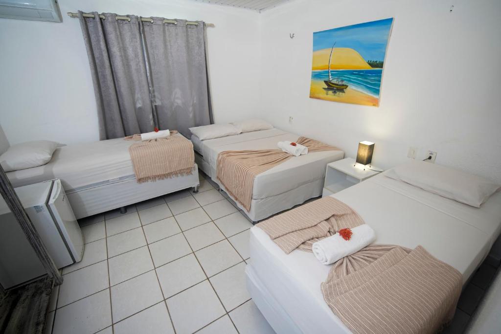 a small room with two beds and a couch at Pousada Hippopotamus Jeri in Jericoacoara