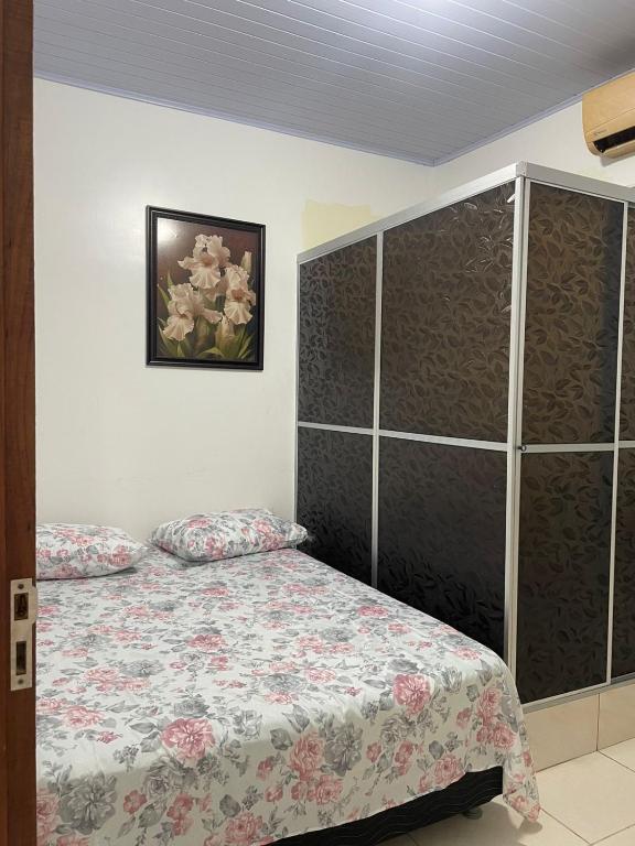een slaapkamer met een bed en een schilderij aan de muur bij Fenix Pousada in Manaus