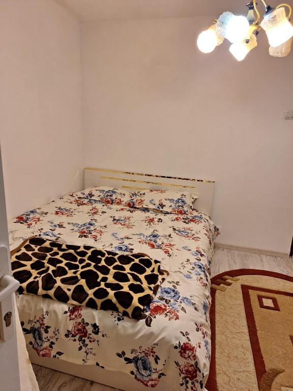 een slaapkamer met een bed met een zwart-wit dekbed bij Ana in Craiova