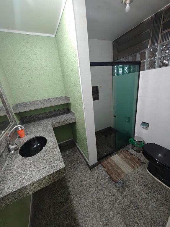 Ruta Amazônica Hostel في بيليم: حمام مع حوض ودش زجاجي