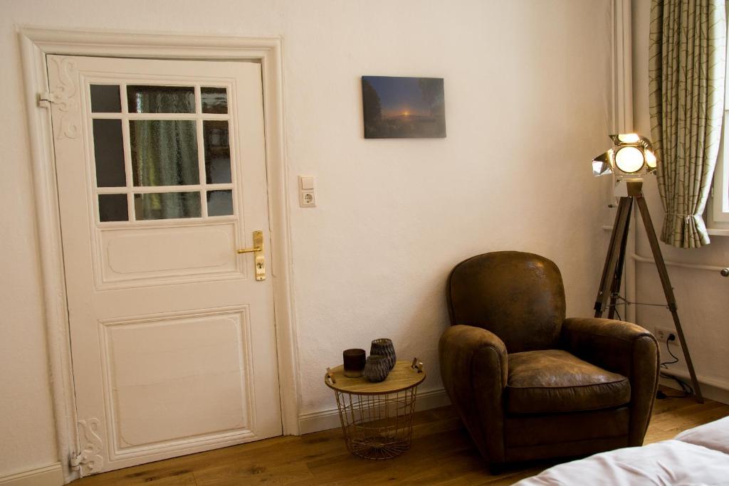Zimmer mit einem Stuhl und einem Tisch mit einer Lampe in der Unterkunft Haus Wunschlos Kirchstraße in Monschau