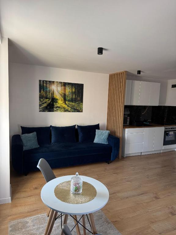 a living room with a blue couch and a table at Studio szczawienko in Wałbrzych
