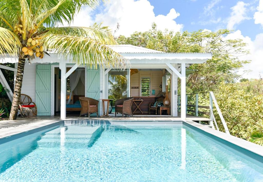 a villa with a swimming pool and a house at La poolhouse in Grand-Bourg