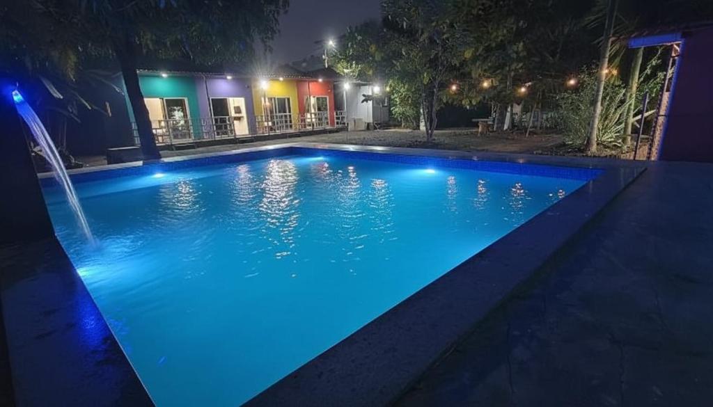 a swimming pool at night with blue lights at Madhurleela Villa in Alibaug