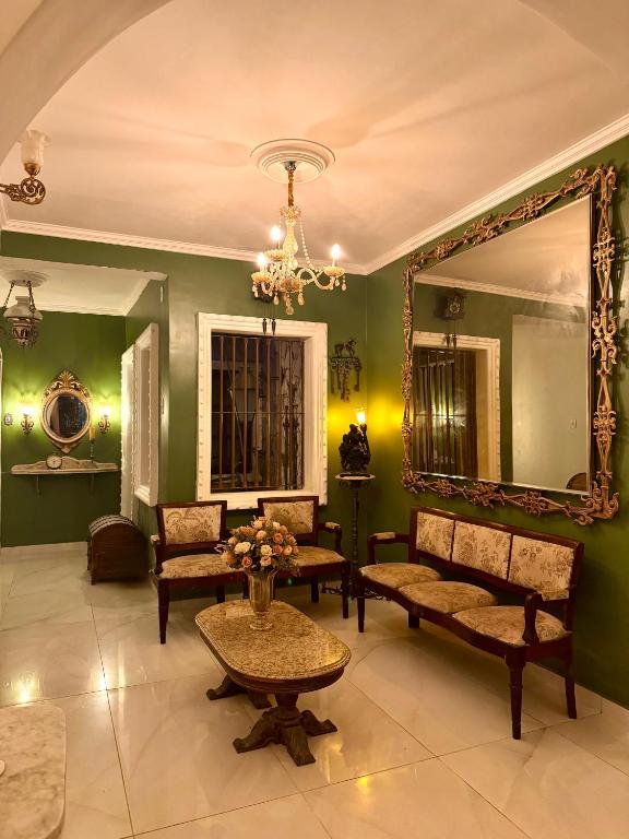 a living room with green walls and a mirror at Casa da Josi - Pajuçara in Maceió