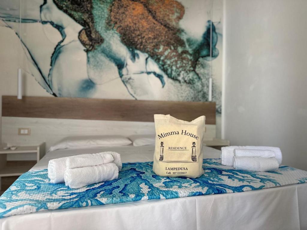 ein Bett mit Handtüchern und eine Tasche darüber in der Unterkunft Mimma house in Lampedusa