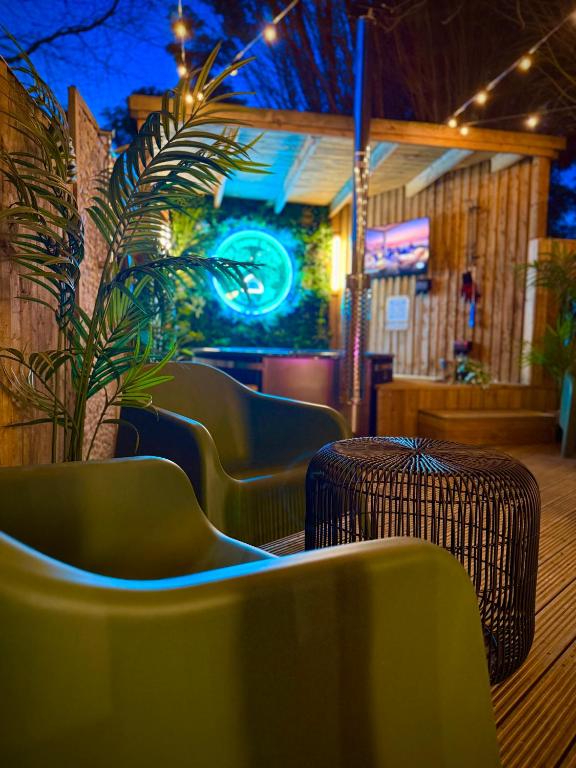 a restaurant with green chairs and a potted plant at The Secret Garden Glamping Lancashire in Skelmersdale