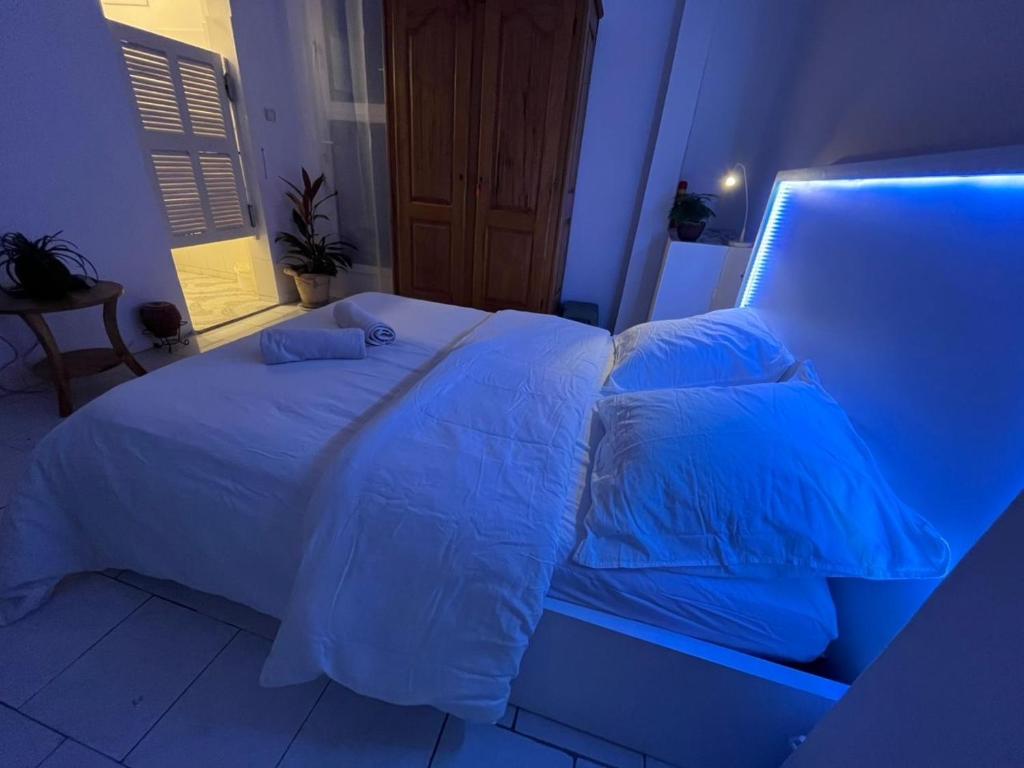 a bedroom with a white bed with blue lighting at Chambre double meublée in Mbour