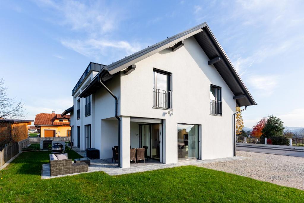 a white house with a black roof at Hiša Urma in Celje