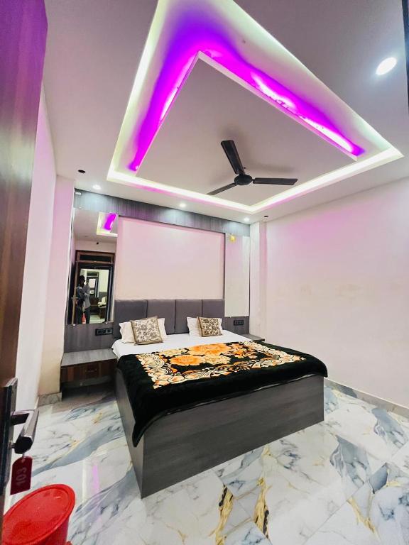 a bedroom with a bed with purple lights on the ceiling at Hotel Kaushalya in Ayodhya