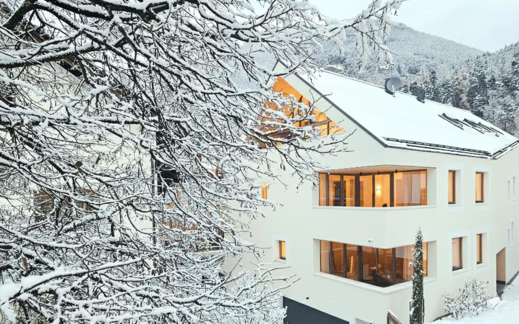 un edificio ricoperto di neve con alberi innevati di Kreithner luxury apartments a Vandoies