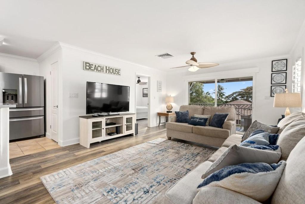 a living room with a couch and a tv at Island Paradise Resort Villa in Honokai Hale