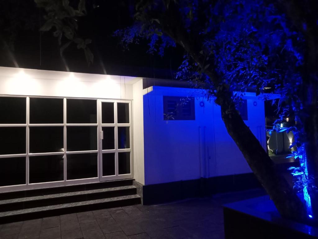 a house lit up at night with blue lights at KODIVEED Heritage in Alleppey