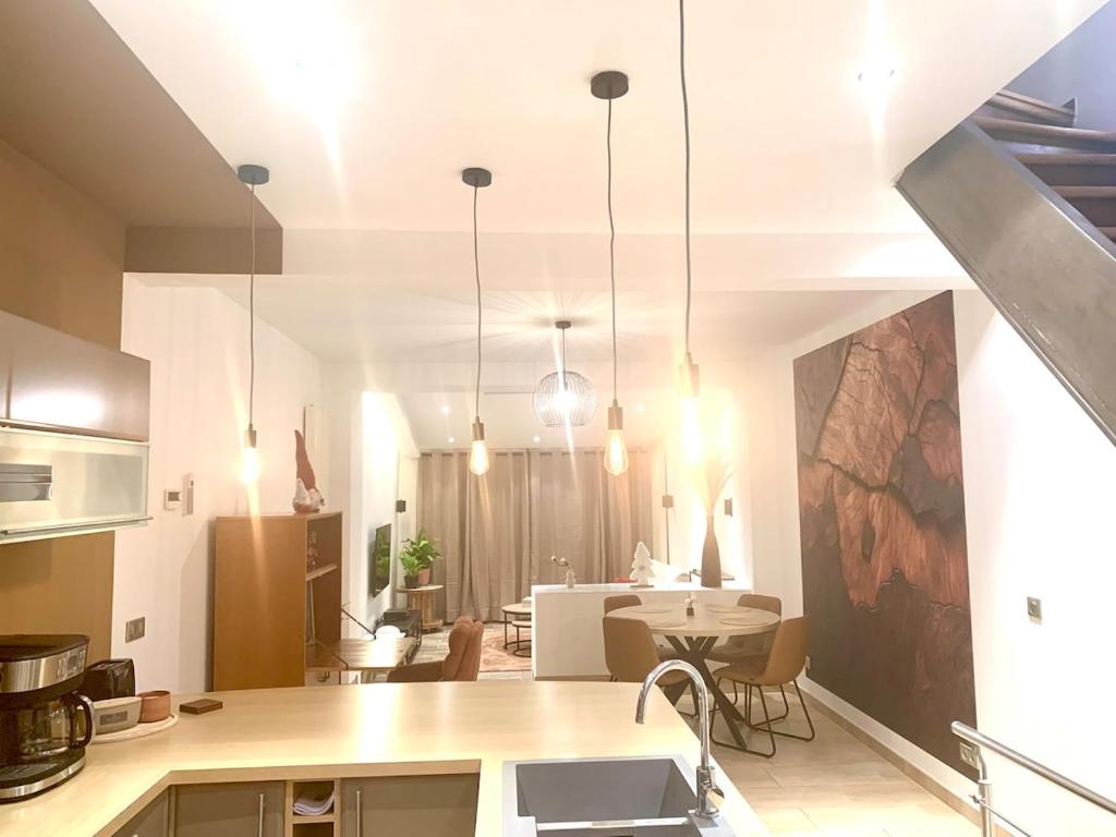 eine Küche und ein Wohnzimmer mit Tisch und Stühlen in der Unterkunft Siena- Maison 6 personnes proche Luxembourg in Longlaville