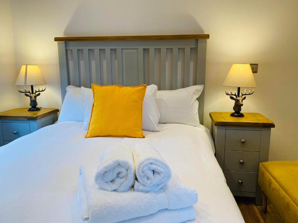 a bedroom with a white bed with towels on it at Luxury Portree Cottage Hillside in Portree