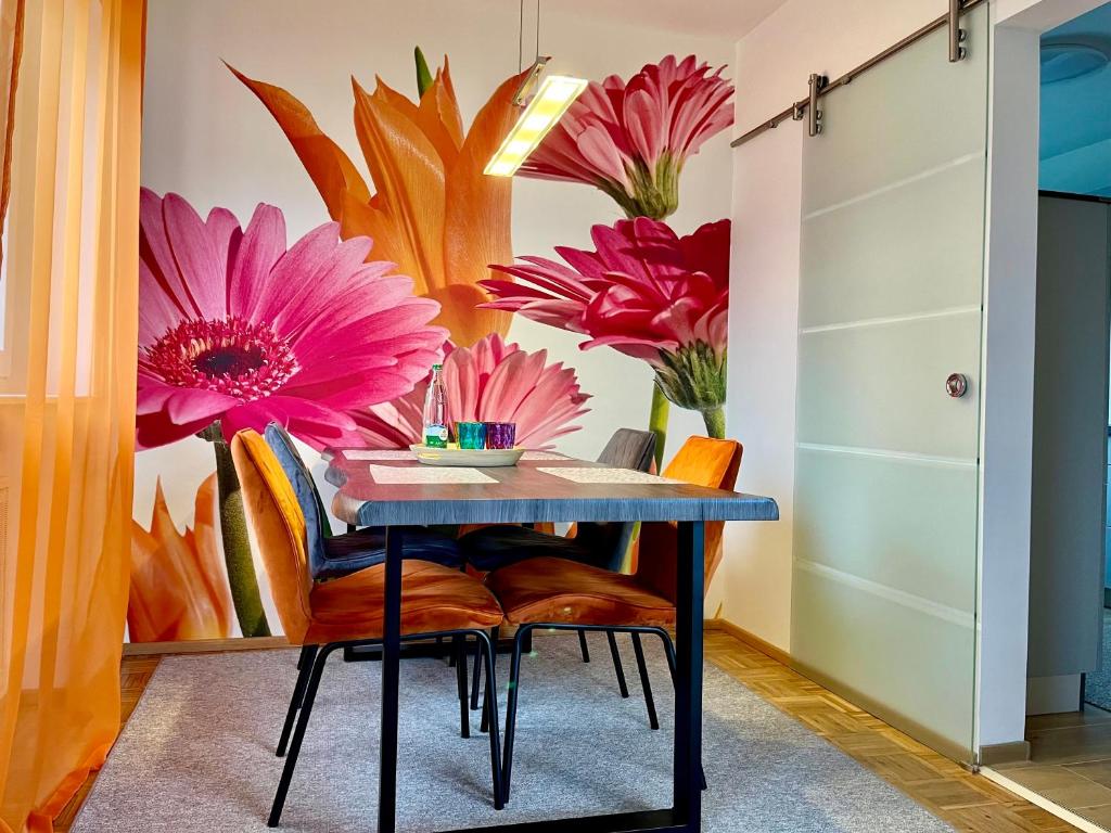a dining room with a table and flowers on the wall at Familienidylle im Altmühltal in Solnhofen