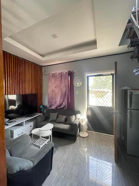 莫阿尔博阿Tiny House in Moalboal Saavedra的客厅里有一张沙发和一张桌子。