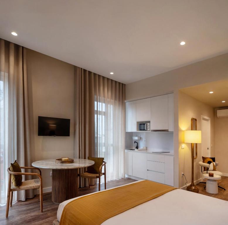 ein Hotelzimmer mit einem Bett und einem Tisch in der Unterkunft Foz Apartments in Figueira da Foz