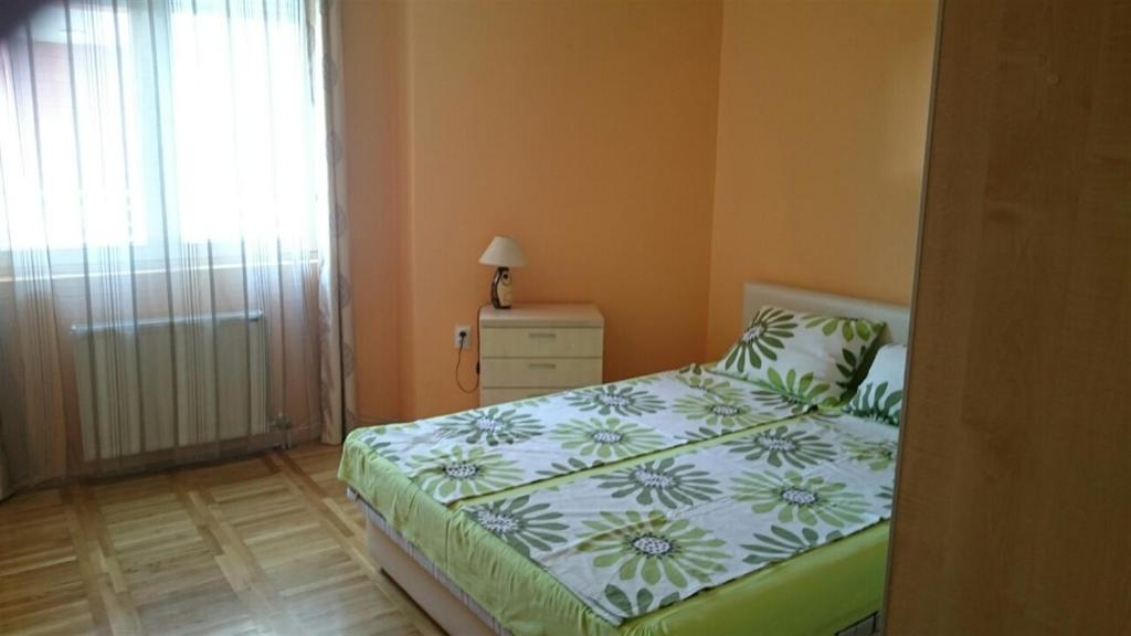 a bedroom with a bed and a dresser and a window at Daria Apartment in Novi Sad