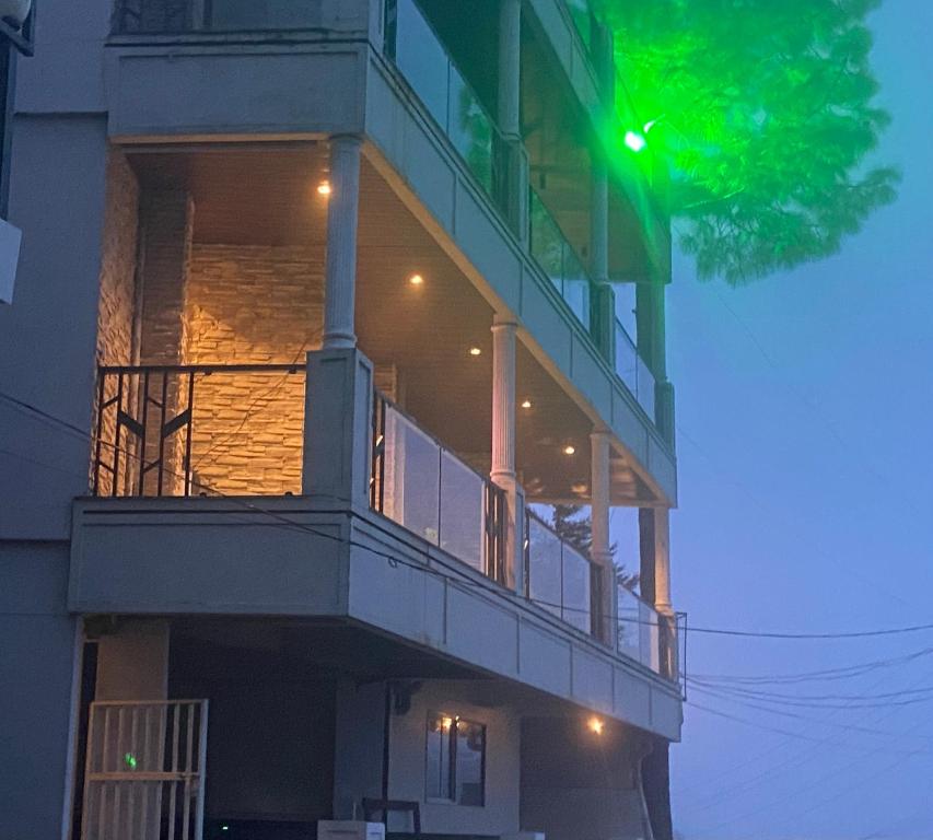 een gebouw met groen licht op het balkon bij The Blessings Annexe in Nainital
