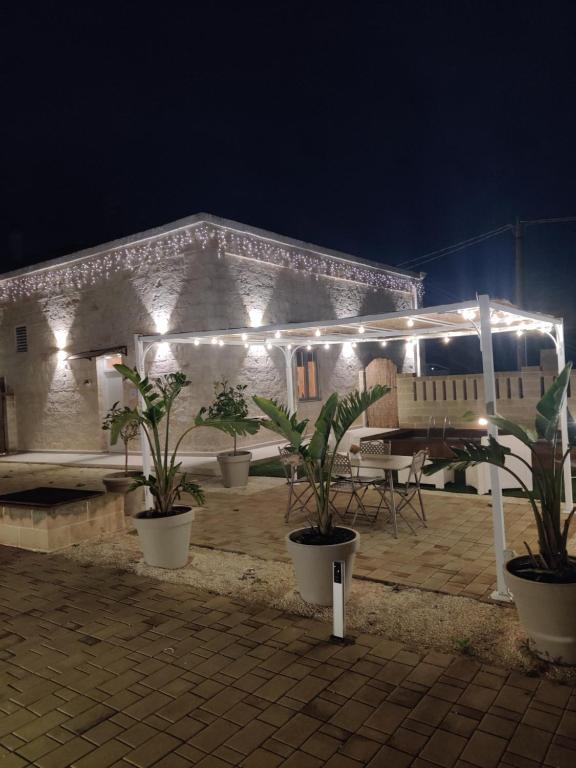 a patio with plants and lights on a building at Victoria's Home in Faccia di Trippa