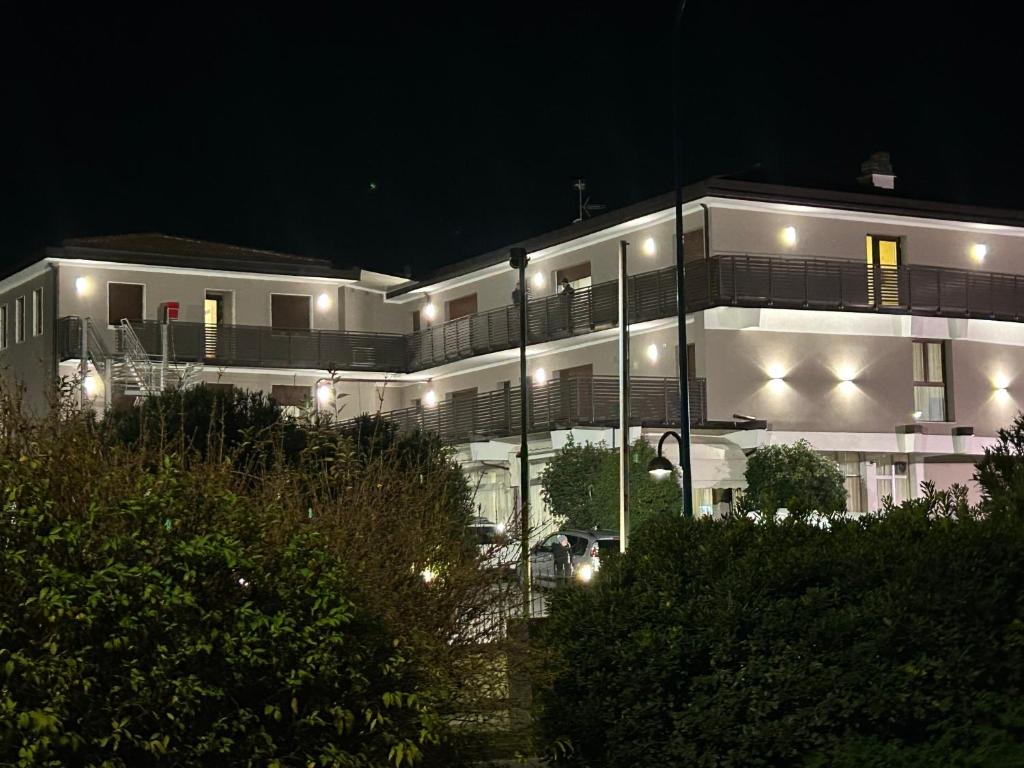 een groot wit gebouw met 's nachts verlichting bij Hotel Marchina in Brescia