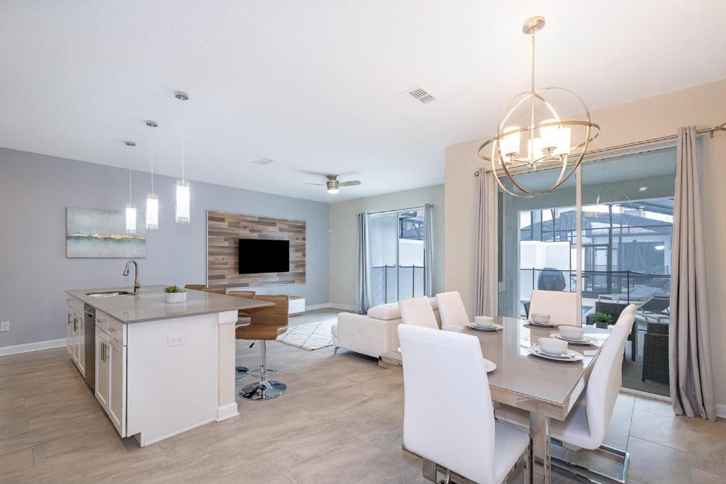 a dining room and living room with a table and chairs at 4809AM TOWNHOUSE 4 BEDROOMS & 3 BATHROOMS + POOL in Kissimmee