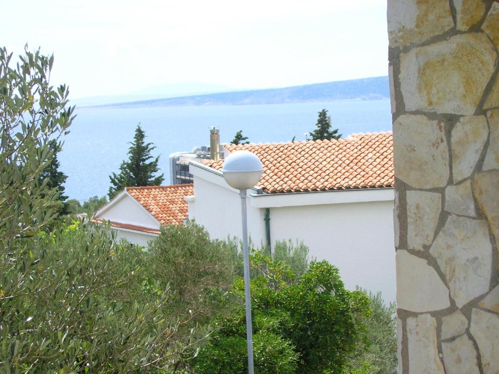 eine Straßenbeleuchtung vor einem Gebäude mit Blick auf das Wasser in der Unterkunft Apartmani Plach in Krk