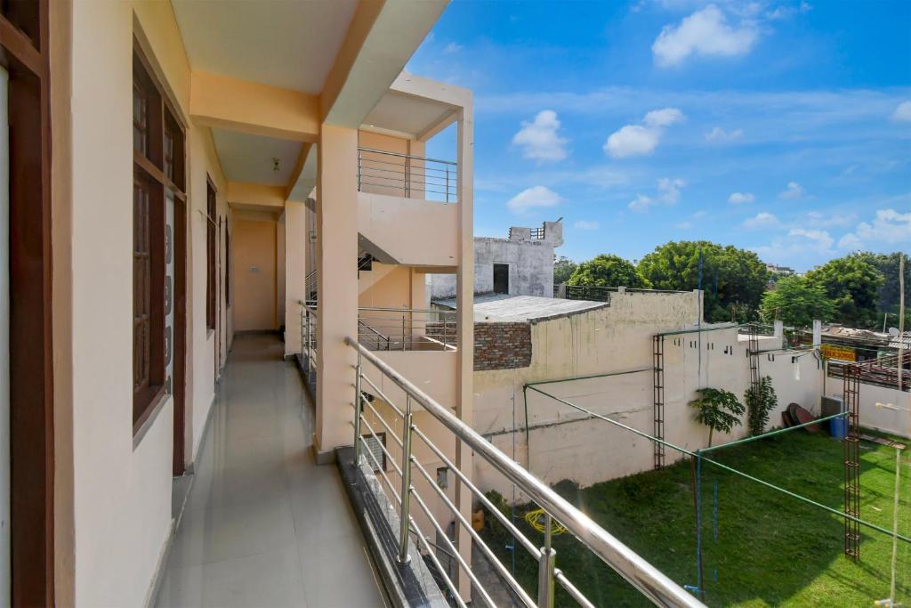 balkon z widokiem na budynek w obiekcie Hotel O New Shagun Vatika Lawn & Hotel w mieście Alambagh