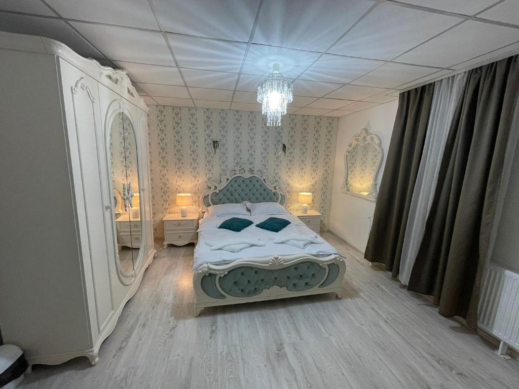a bedroom with a bed and a chandelier at Pensiunea Canciu in Craiova