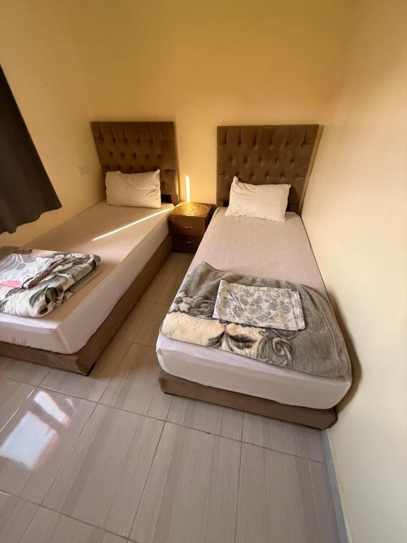 two beds in a small room with at Résidence AGDAL in Dakhla
