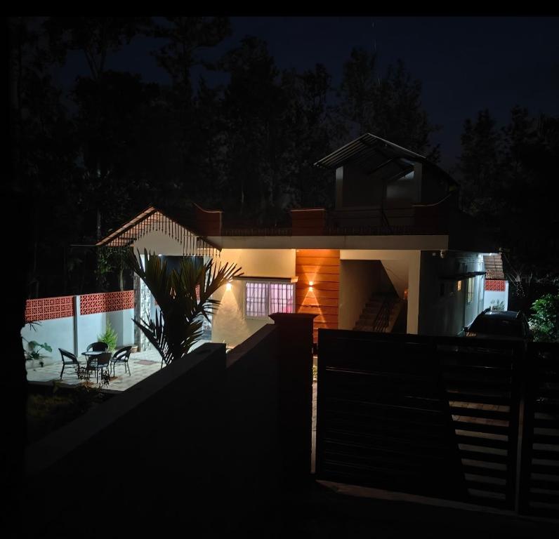 SomvārpetにあるNature Chirps Coorg farmview villaの塀で夜灯が灯る家