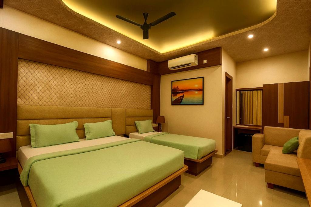 a bedroom with two beds and a couch at Rooftop Sea View the KP Palace Near Jaganath temple - Restaurant # Lift and Free Parking Facilities # Fully Air Conditioning Hotel - Luxuary Hotel Prime Location in Puri