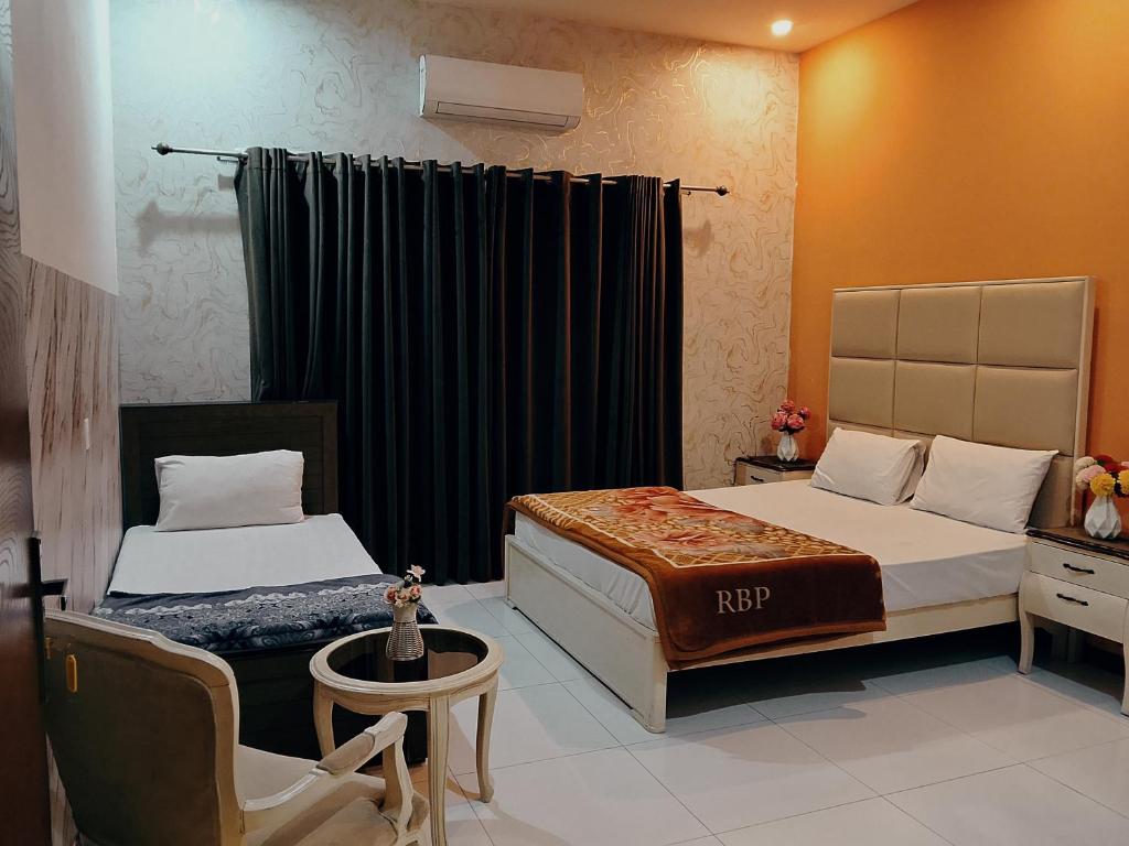 ein Hotelzimmer mit zwei Betten und einem Stuhl in der Unterkunft Professional lodges in Islamabad