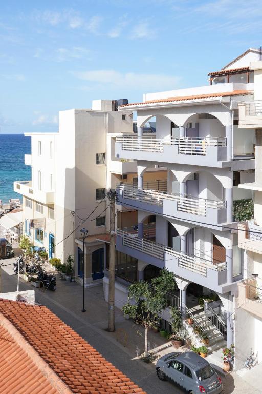 an apartment building with balconies and the ocean at Posidonio Hotel in Chania
