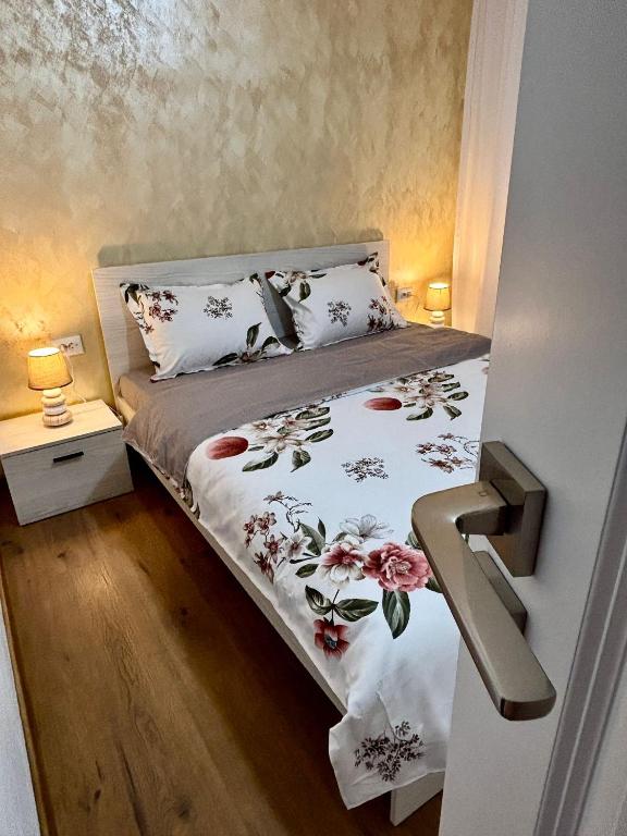a bedroom with a bed with a floral bedspread at Signature Studio Arad in Arad