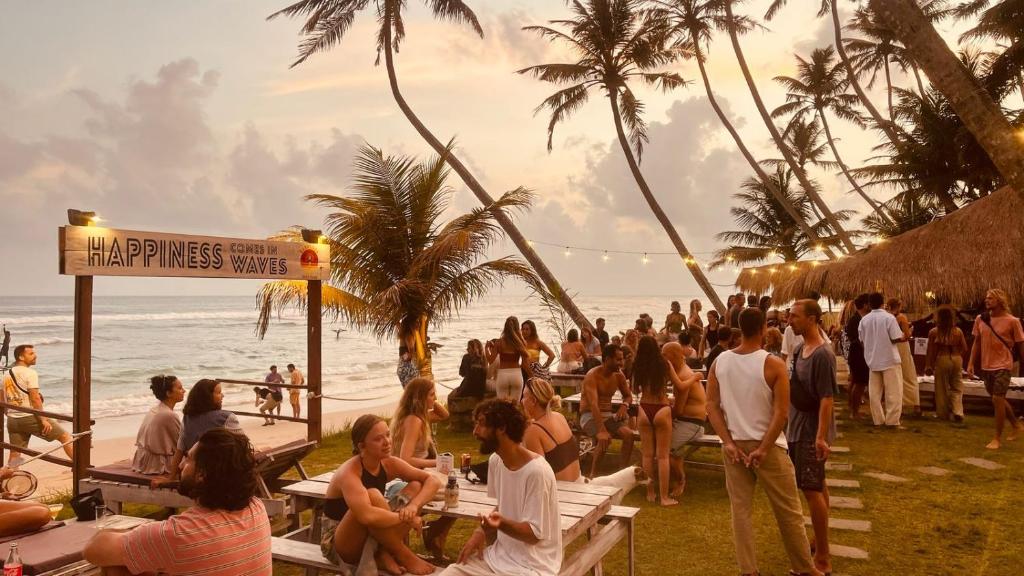 a crowd of people sitting on the beach at Kabalana Surf Hostel in Ahangama