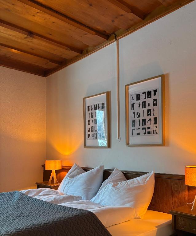 a bedroom with a bed with two pictures on the wall at Ferienhaus s'Mosern in Grundlsee