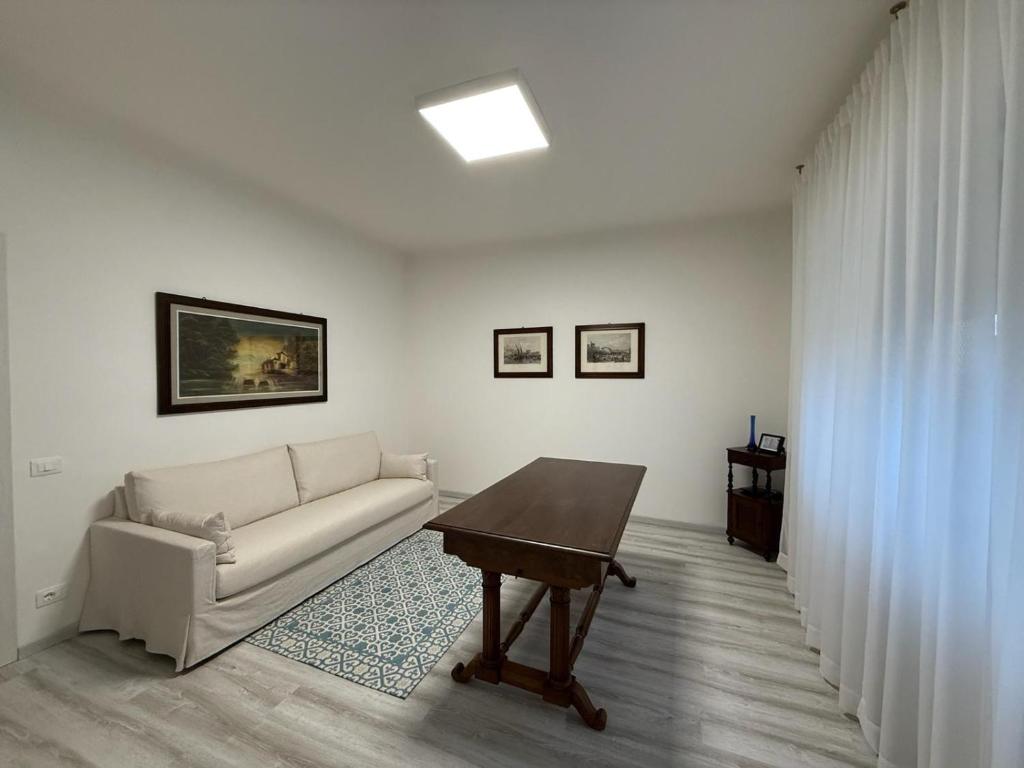 ein Wohnzimmer mit Sofa und Tisch in der Unterkunft Elena's apartment - casa gialla in Quartesana