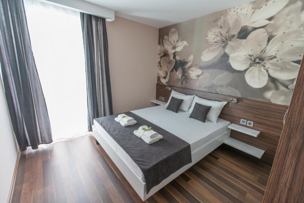 a bedroom with a bed with two towels on it at Garni Hotel Niš City View in Niš