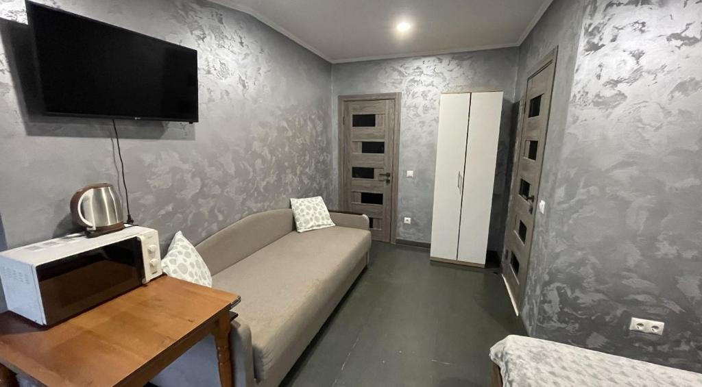a living room with a couch and a tv on the wall at Family2 in Mukacheve