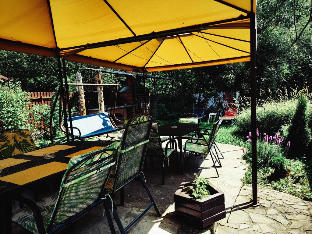 a patio with a table and a yellow umbrella at Casa Crissio in Sinaia