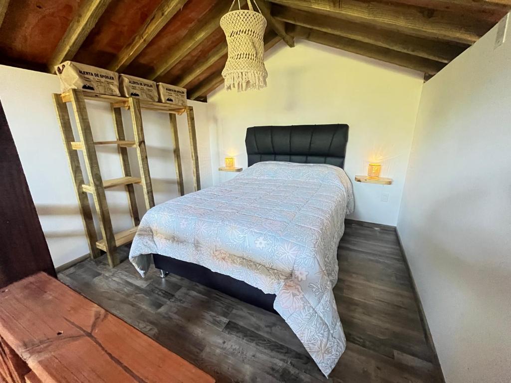 a bedroom with a bed in a room with wooden floors at Punta Negra - Cabañas Cacarelhos in Piriápolis