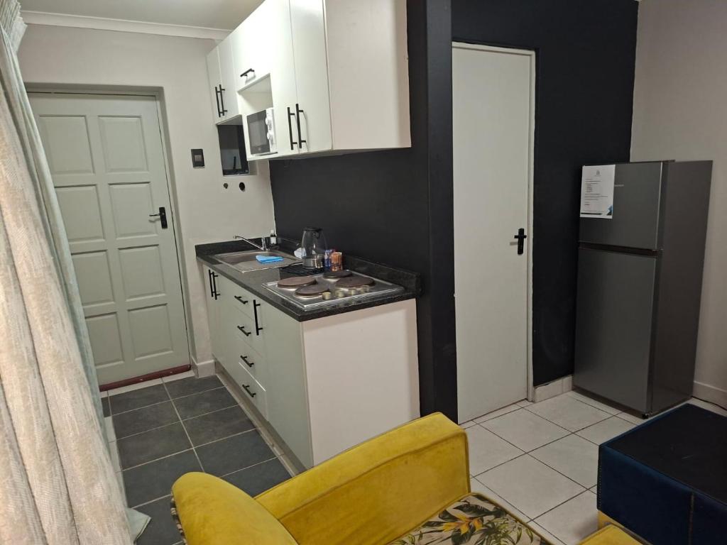 Grace Villas 3 في شرق لندن: مطبخ صغير مع حوض وثلاجة