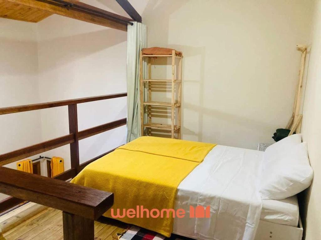 una camera da letto con un letto con una coperta gialla di Chale Manticas aconchego na Serra da Mantiqueira a Costas